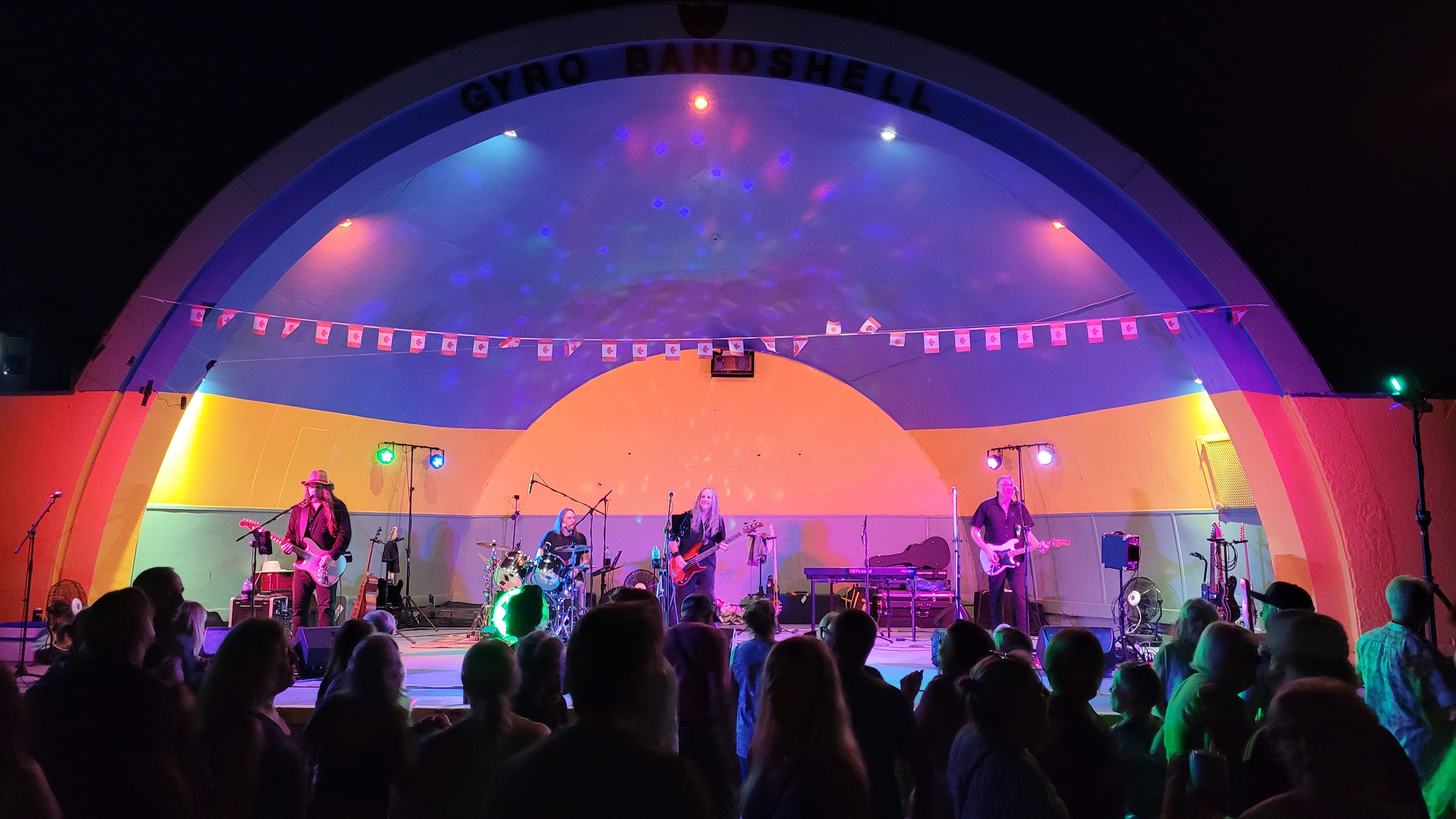 Rock band Eagle Eyes performing under vibrant stage lighting at night